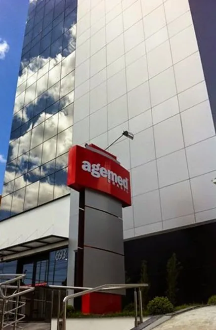 Fachada do prédio da Agemed Planos de Saúde, com a logomarca vermelha da operadora no alto do edifício