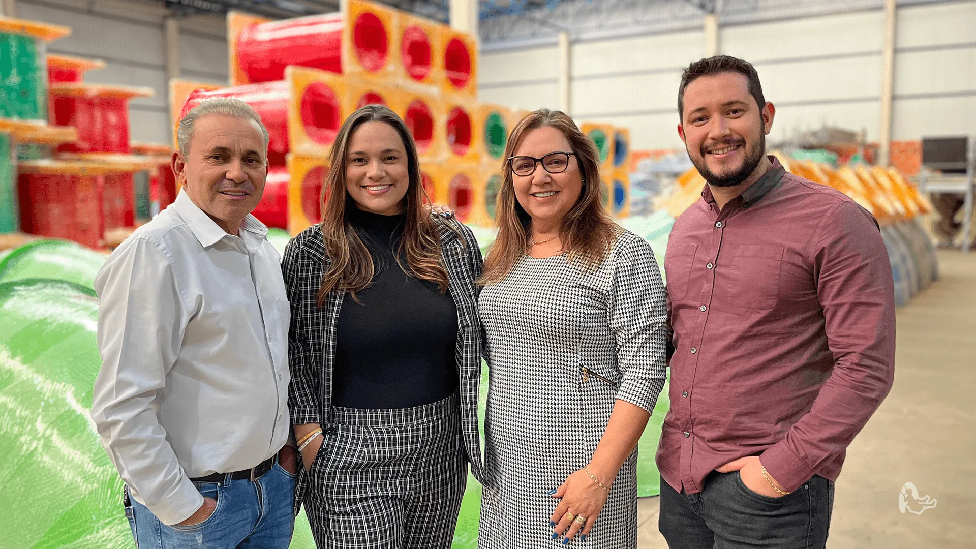 Equipe da Aquarela Parques posando na diretoria com playground ao fundo