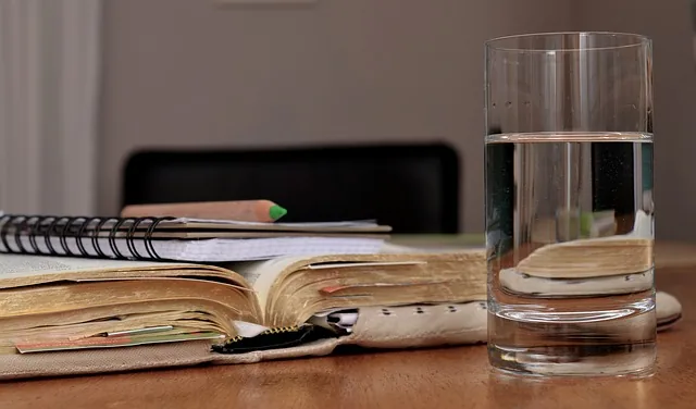 Mesa de trabalho com livro, caneta e ferramentas para consolidação de demonstrações financeiras
