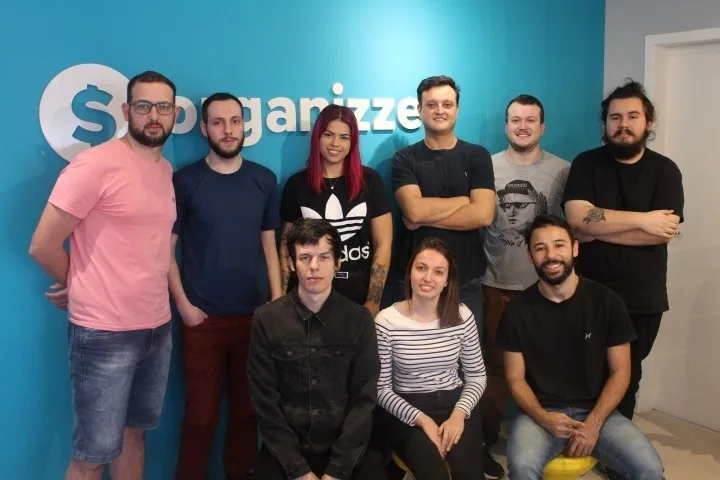 Equipe Organizze reunida com logo marca app finança sucesso colaboração