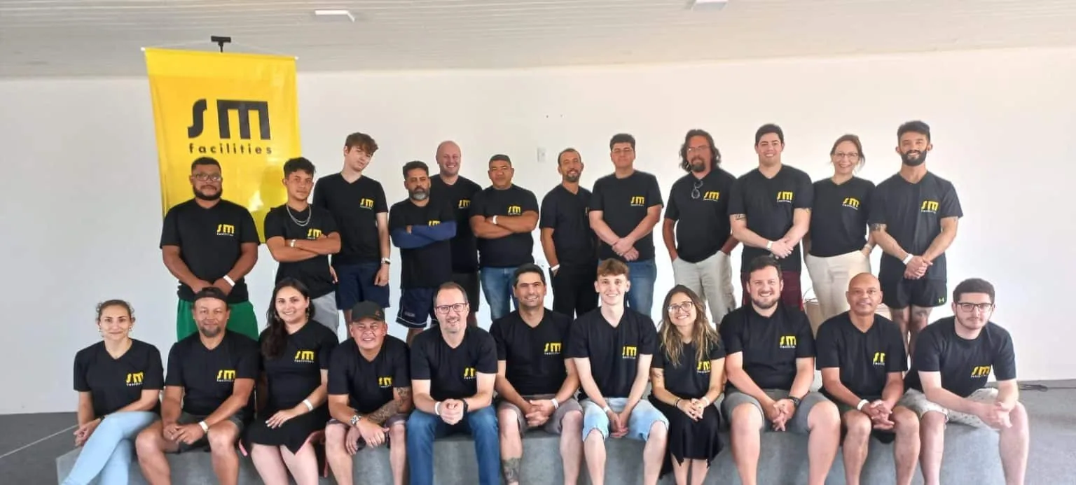 Time profissionais uniformizados sm facilities posando câmera equipe empresa serviços gestão